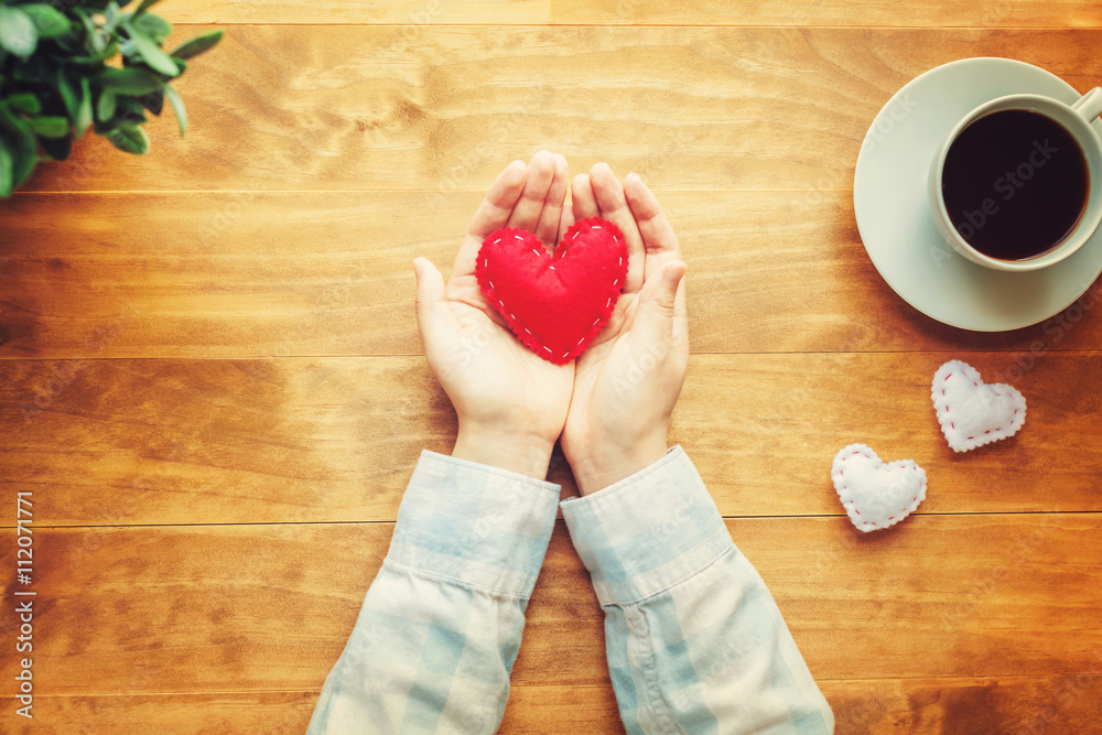 Person holding a handmade red heart