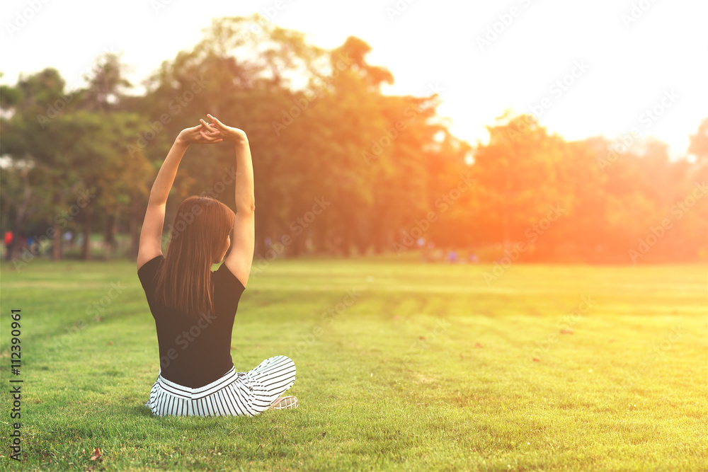 Young woman practicing yoga at a park in morning.