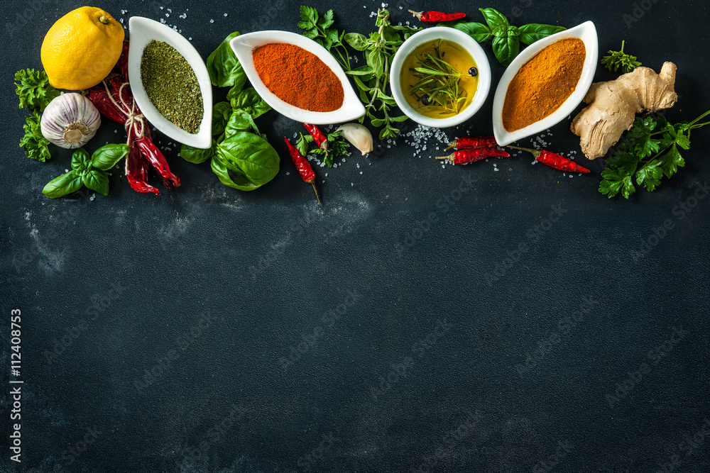 Herbs and spices over black stone background