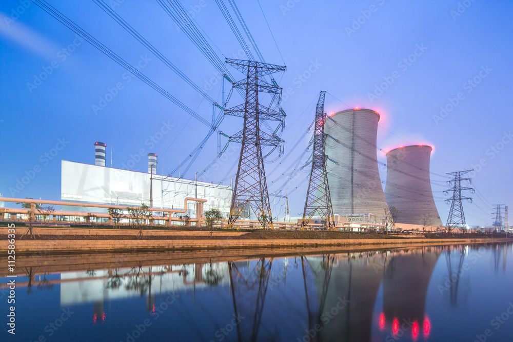 modern factory near river in blue sky at dawn