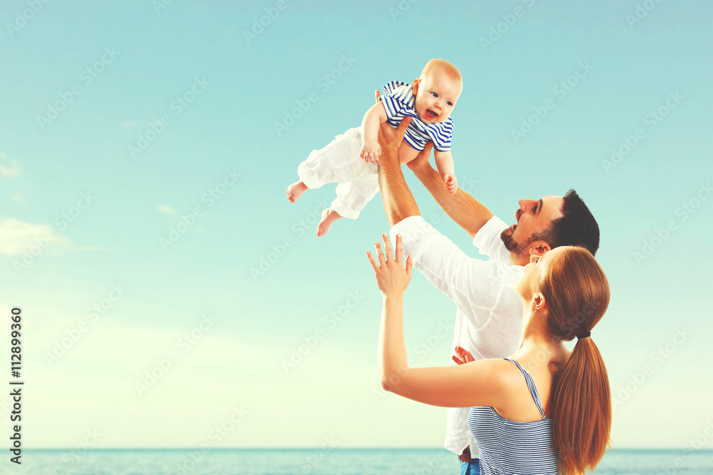 happy family mother, father and baby on sea