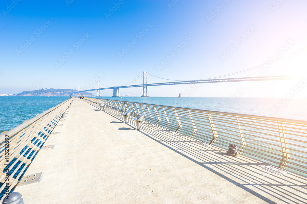 empty pedestrian bridge near bay bridge in san francisco with su