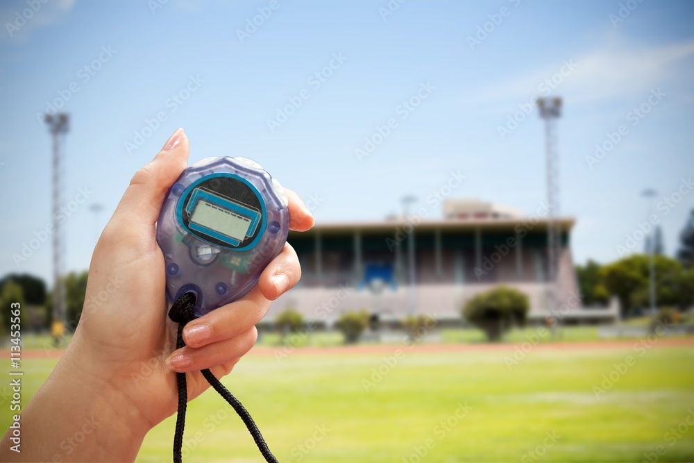 Close up of a hand holding a stopwatch on a sport field