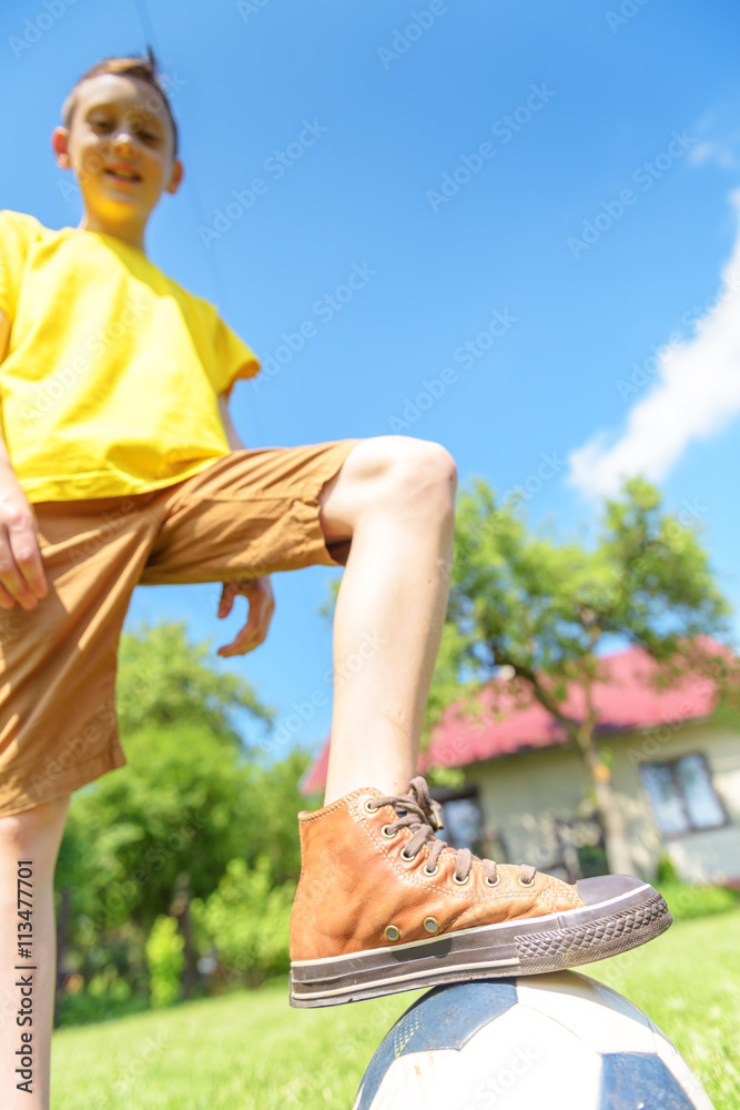 Boy with ball on green lawn. Summer time!