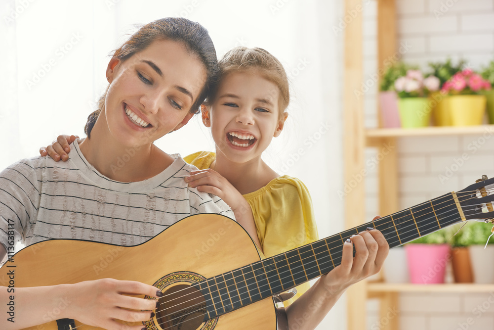 Mother and daughter playing guitar