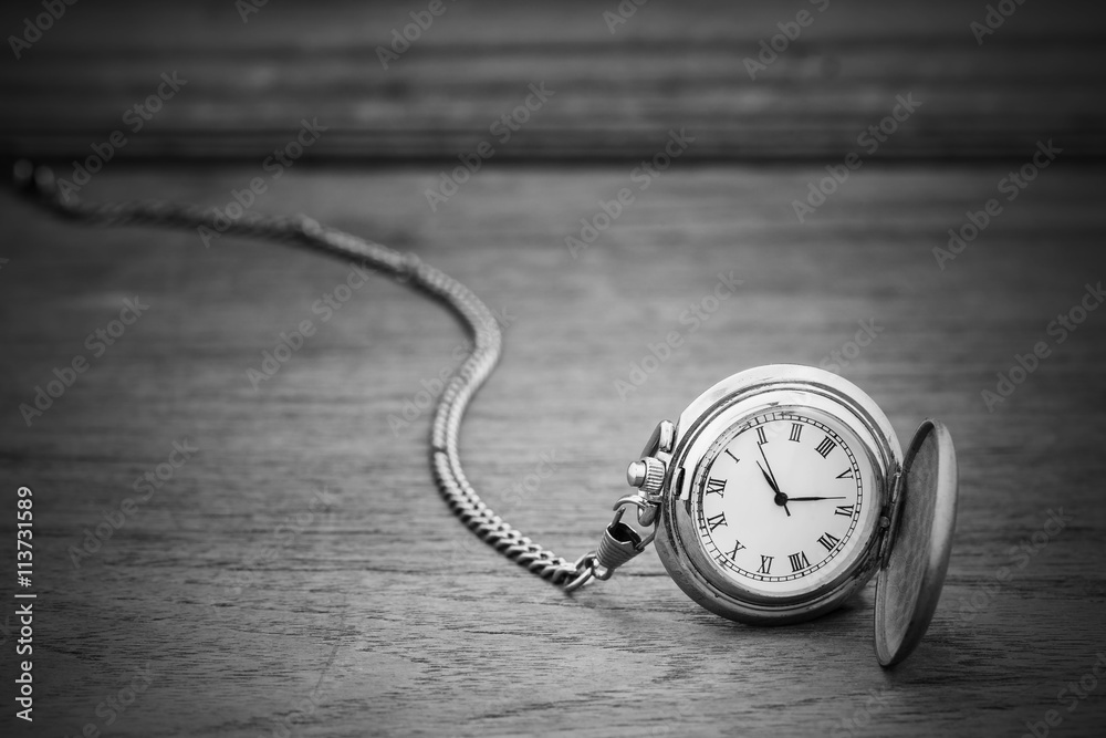 Old pocket watch on wood background.