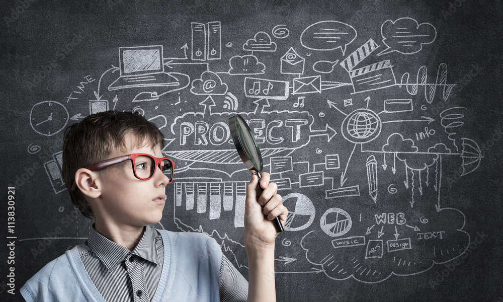 Curious school boy with magnifier