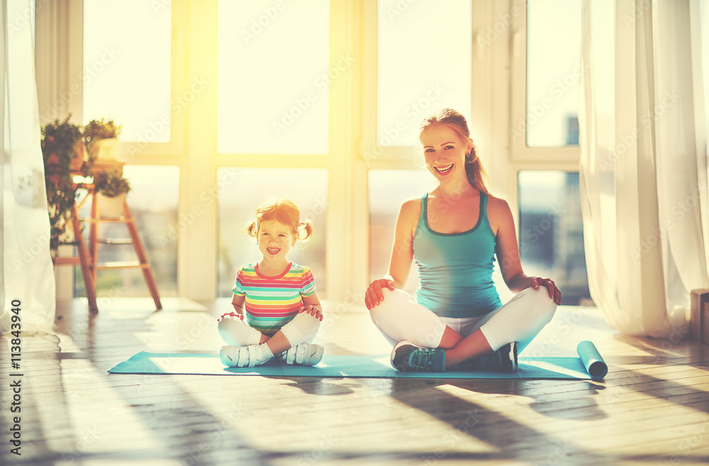 family mother and child daughter are engaged in meditation and y