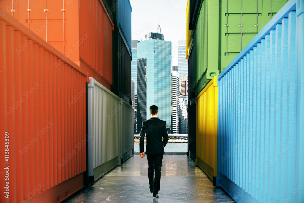 Businessperson between cargo containers