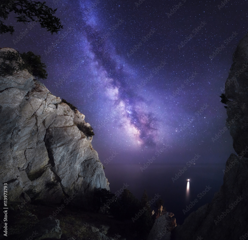 美丽多彩的夜景，有银河、岩石、大海和星空。山景。Am