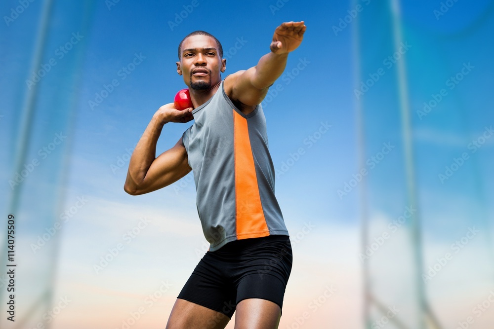 Composite image of front view of sportsman practising shot put 