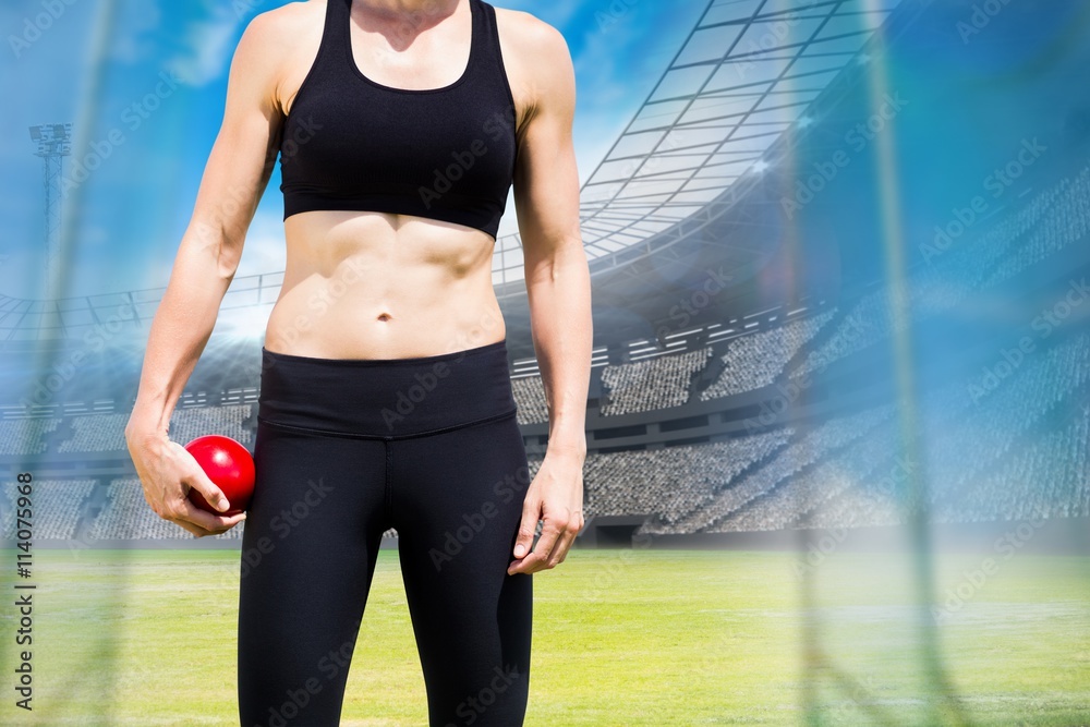 Composite image of sporty woman holding a red ball