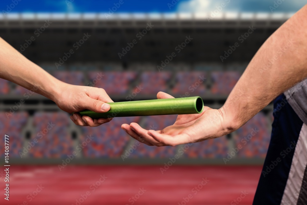 Composite image of man passing the baton to partner on track