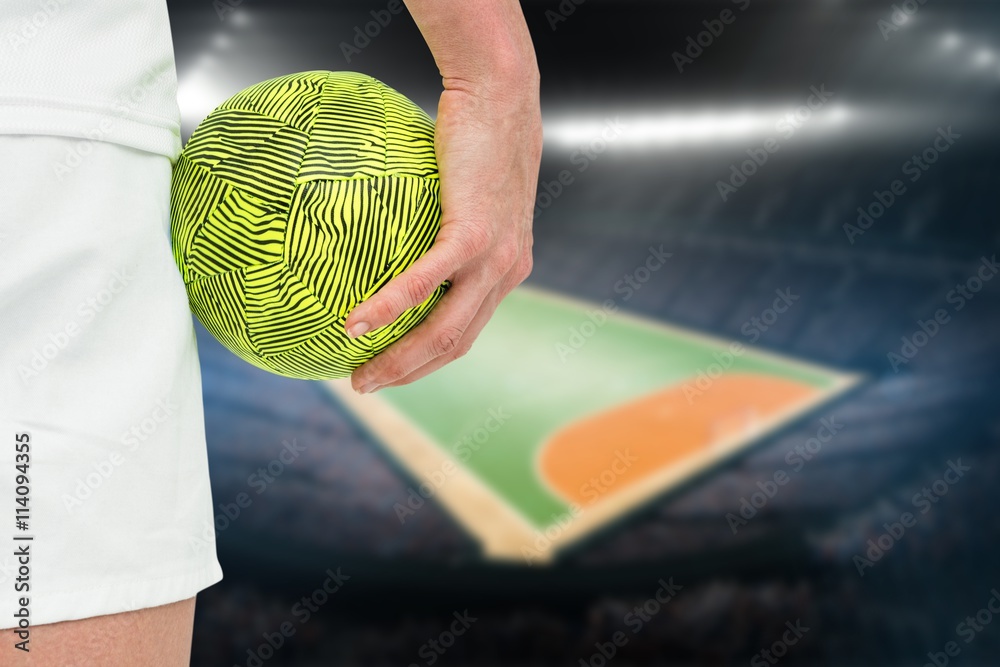 Composite image of sportswoman holding a ball