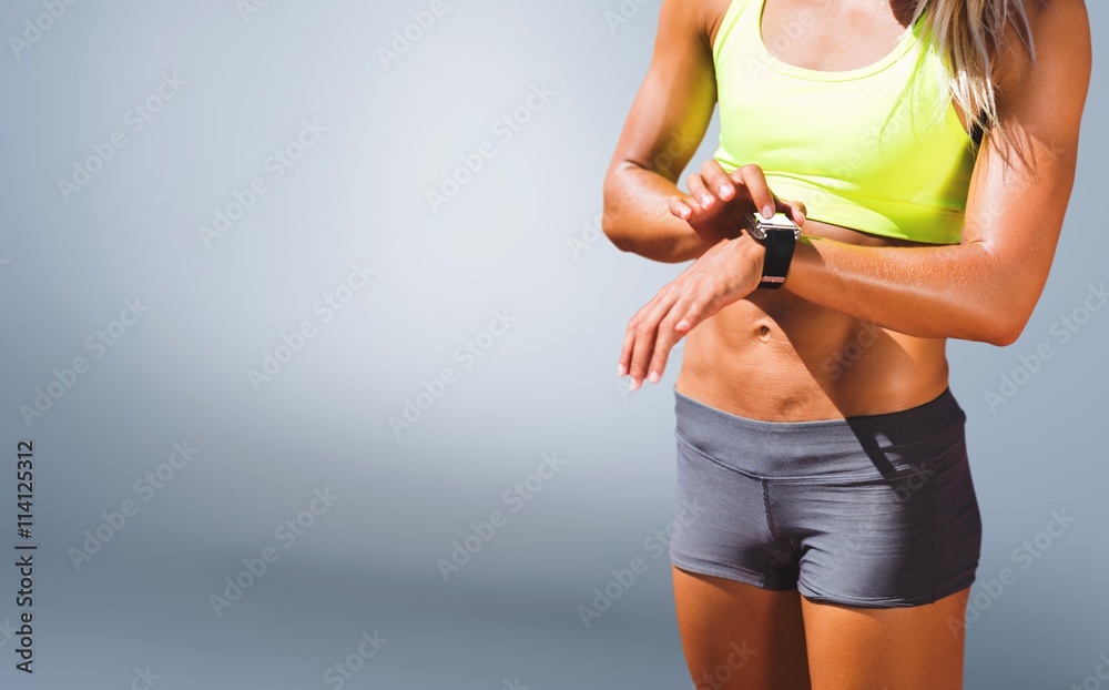 Composite image of sporty woman looking her watch