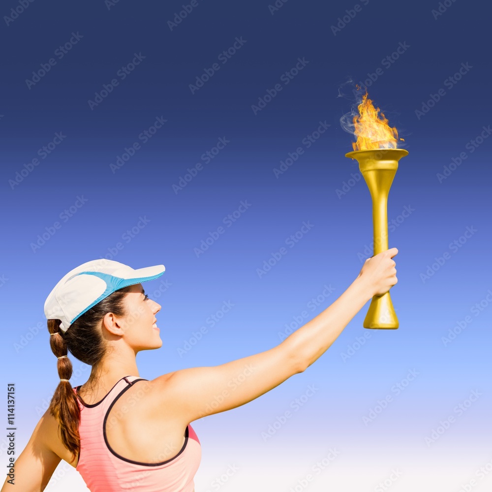 Composite image of rear view of happy sportswoman holding a cup 