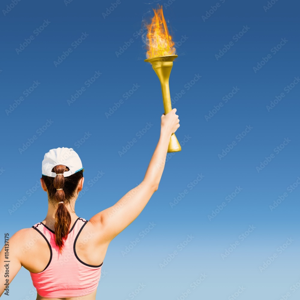 Composite image of rear view of sportswoman raising a cup 