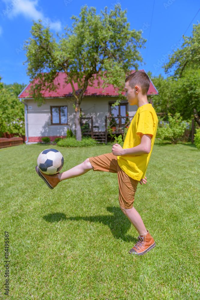 Boy with ball on green lawn. Summer time!