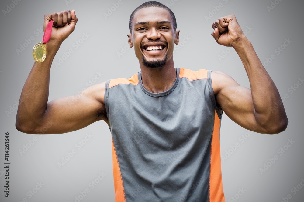 Composite image of happy sportsman smiling and holding medals 