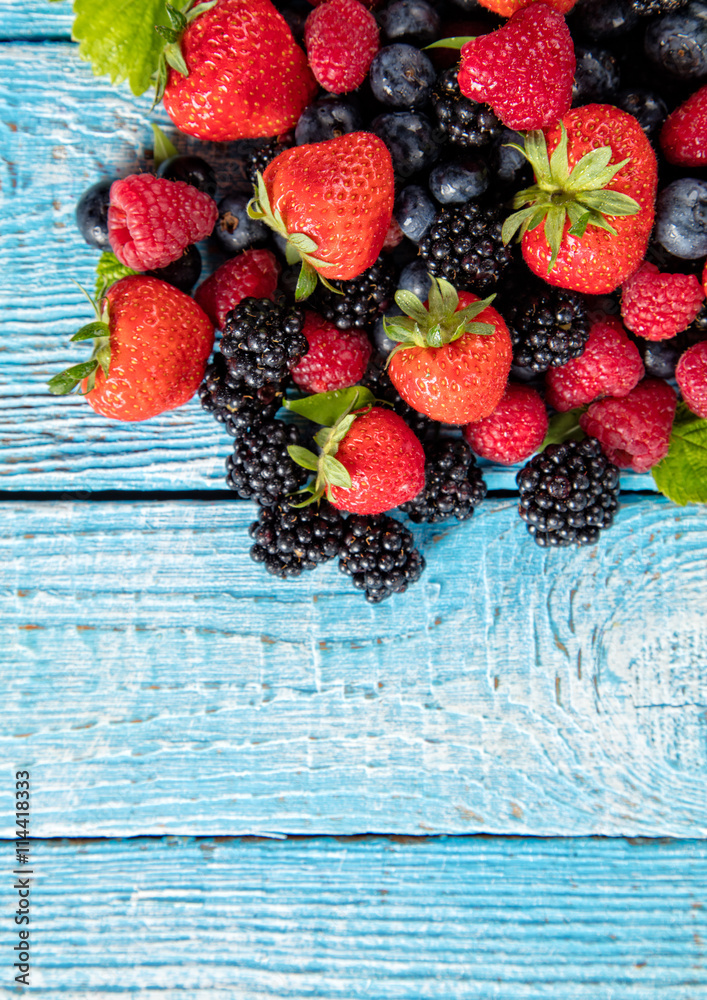 Fresh berry fruit pile placed on old wooden planks