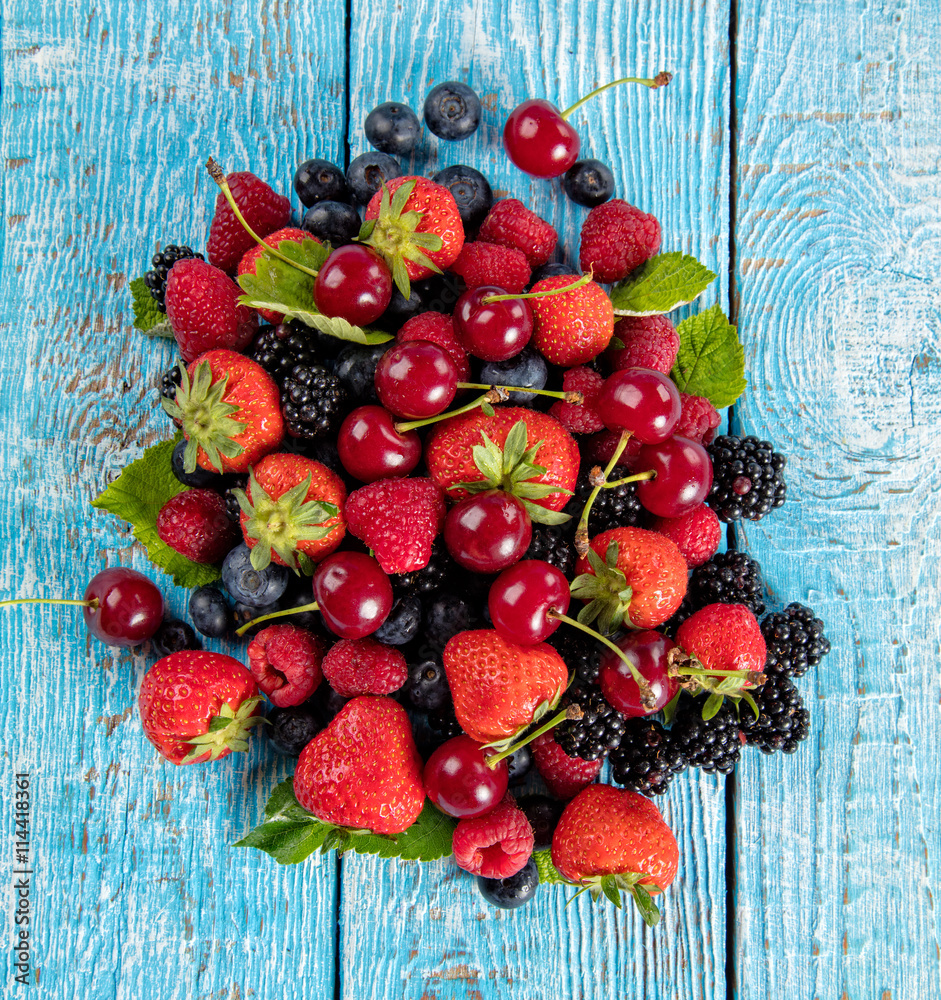 Fresh berry fruit pile placed on old wooden planks