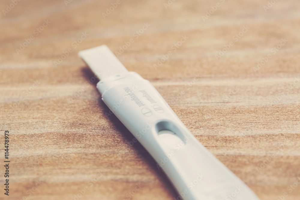 Pregnancy test kit on a wood desk