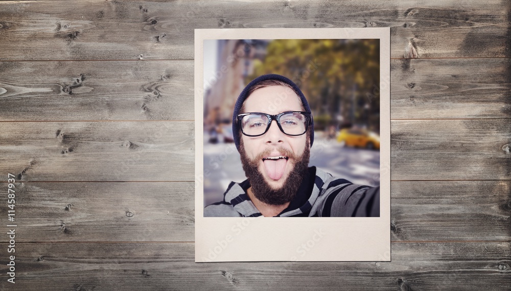 Composite image of happy hipster against wooden fence