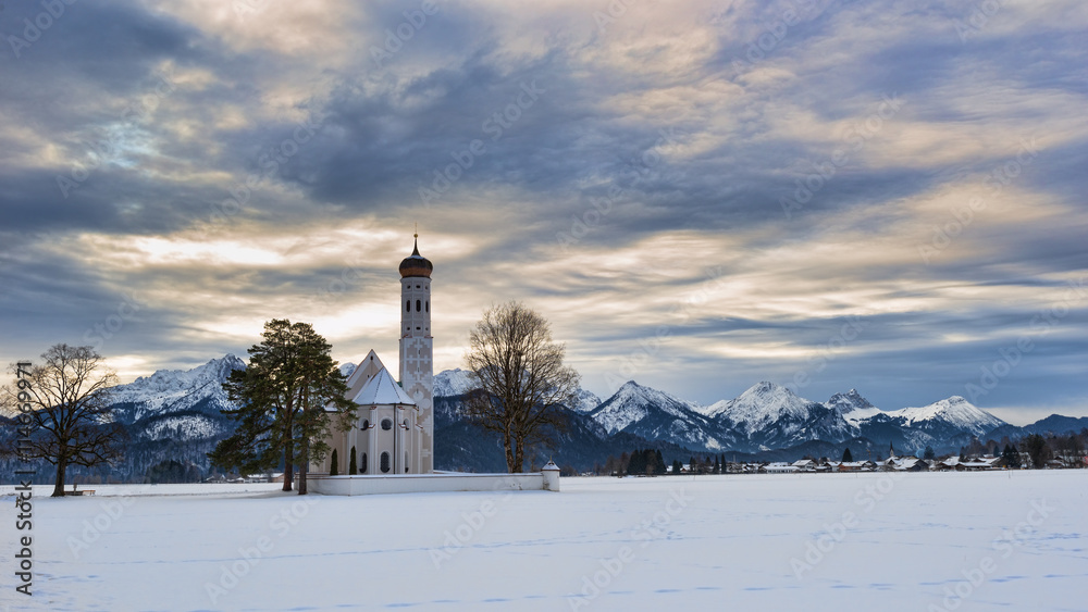 Panoramic view of scenic idyllic winter landscape in the Bavarian Alps with St. Coloman chapel