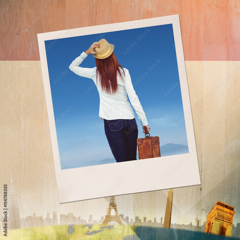 Composite image of rear view of hipster woman holding suitcase