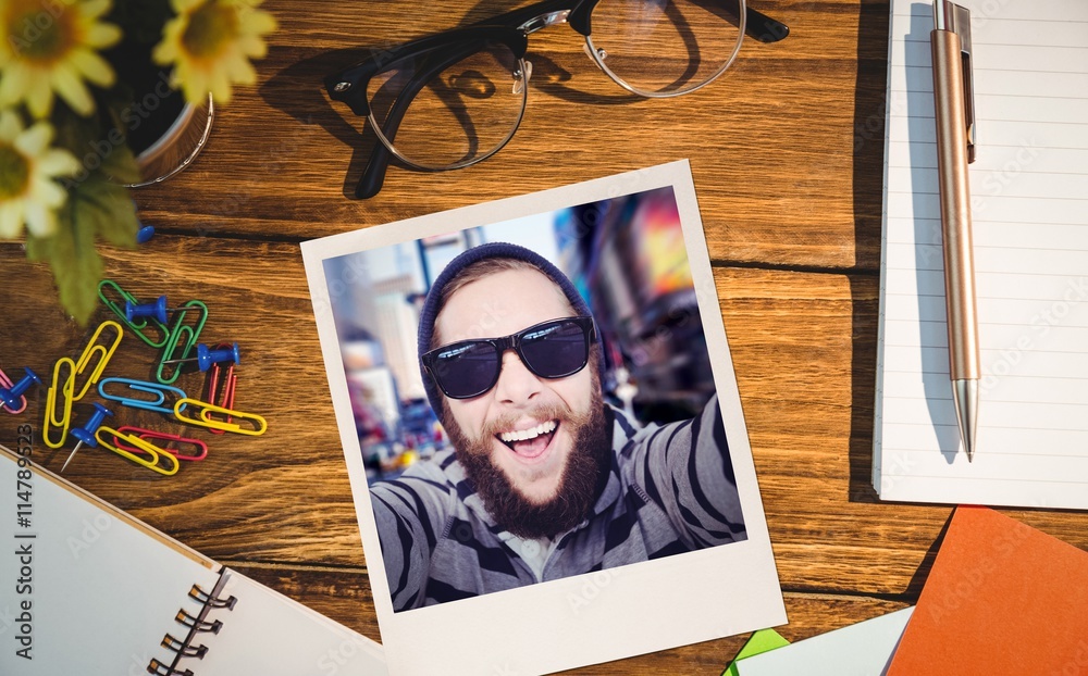 Composite image of happy hipster against wooden fence