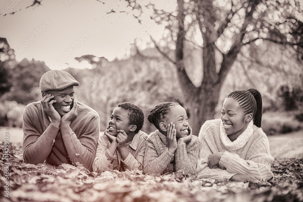 Portrait of a young smiling family lying in leaves