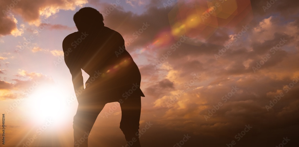 Composite image of athletic man resting with hands on knees