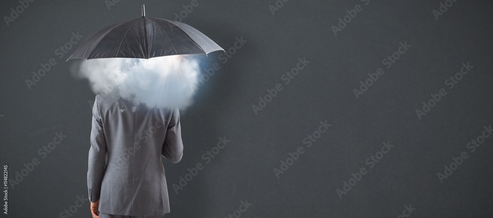 Composite image of businessman standing under umbrella