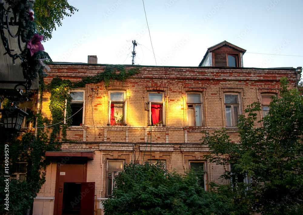 facade of stone house with window and red curtains