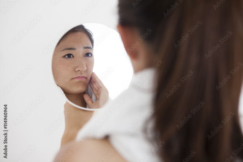 Women have a melancholy look look in the mirror