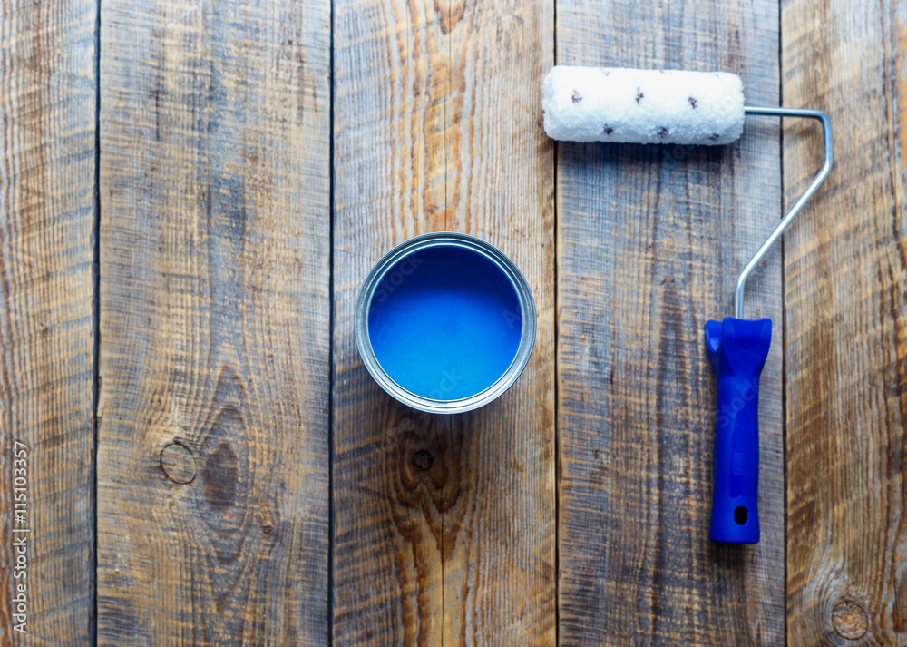 painting with can of blue paint and roller top view