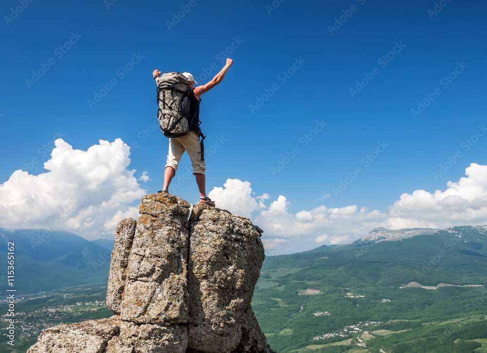 Tourist on the peak of high rocks. Sport and active life concept.