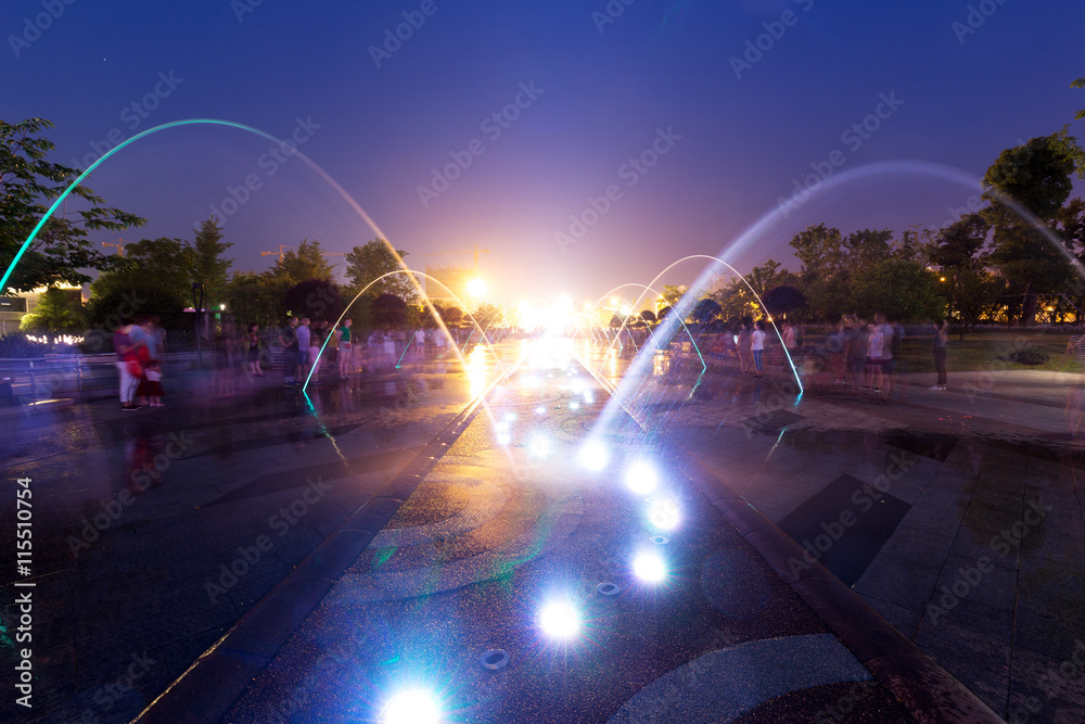 night scene of street with fountain and people in hangzhou