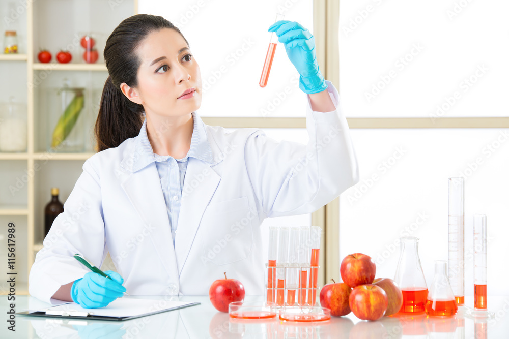 scientist looking the tube and recording science change