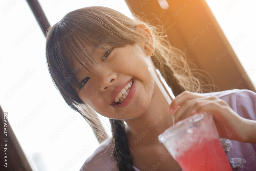 Happy Asian girl drinking ice strawberry smoothie in cafe