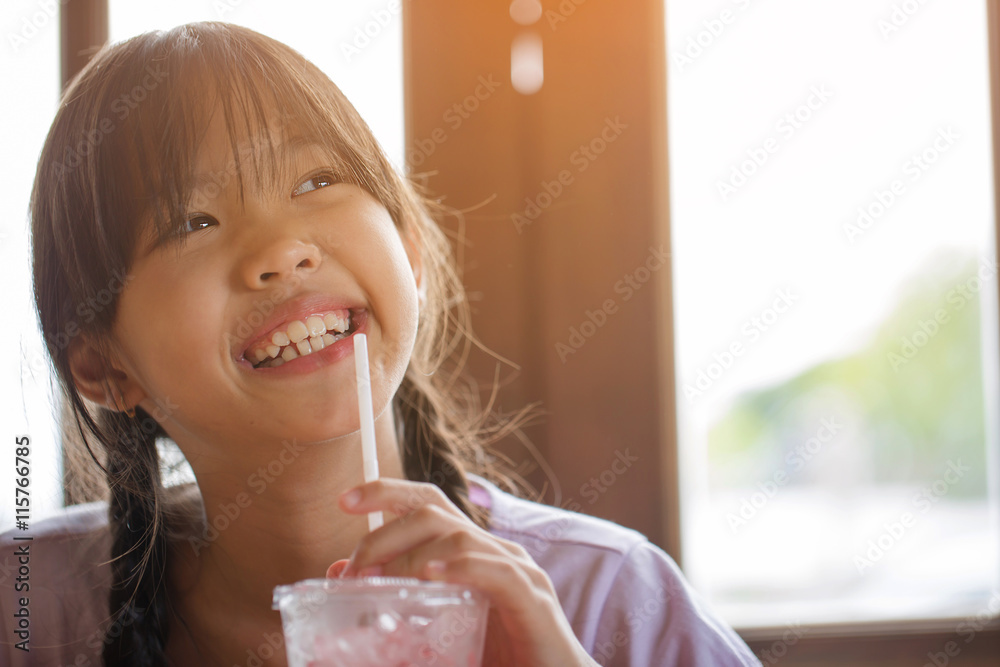 Happy Asian girl drinking ice strawberry smoothie in cafe