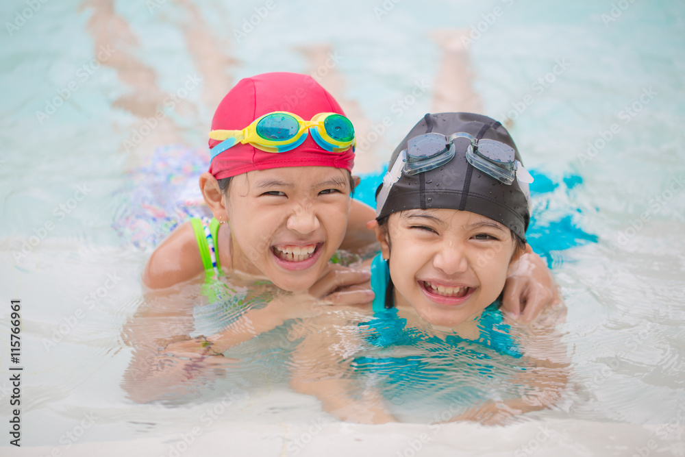 Happy Asian sibling girl playing in the swimming pool