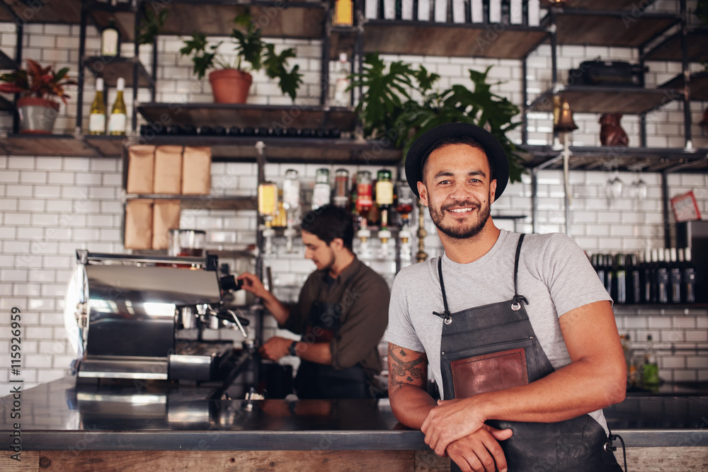 Male coffee shop owner standing at the counter