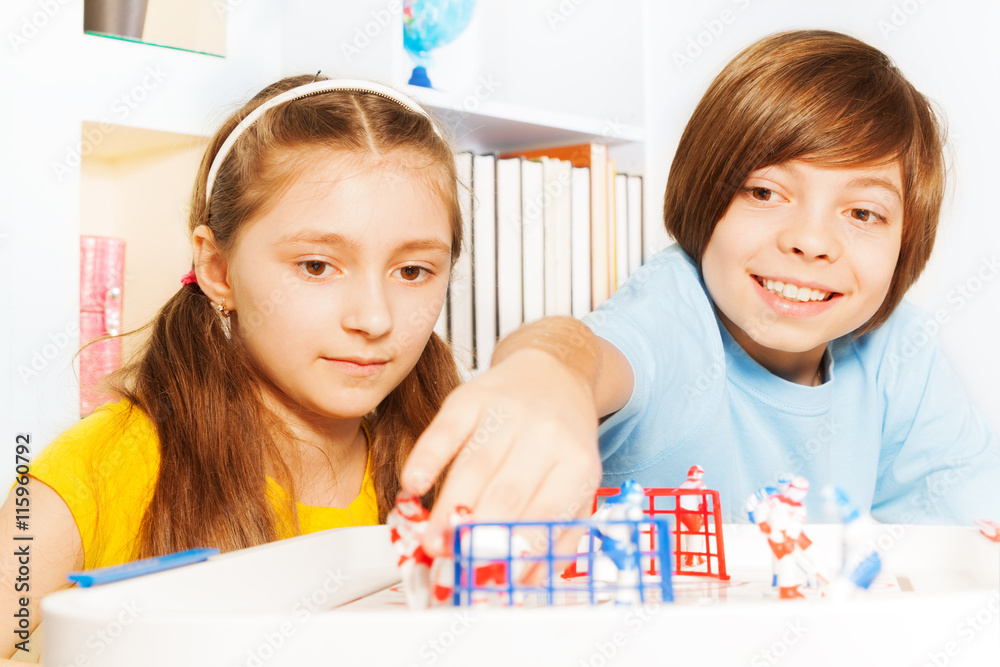 Boy and girl playing ice hockey table board game