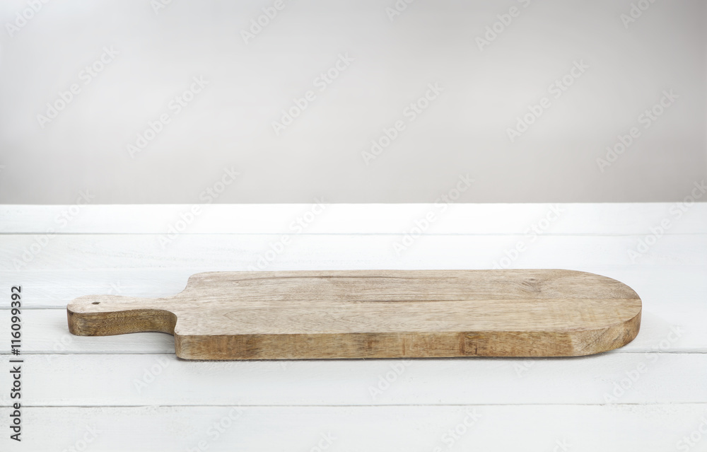 Empty cheeseboard on white wooden table.