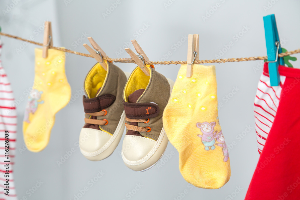 Baby shoes hanging on a rail junction on the white background.