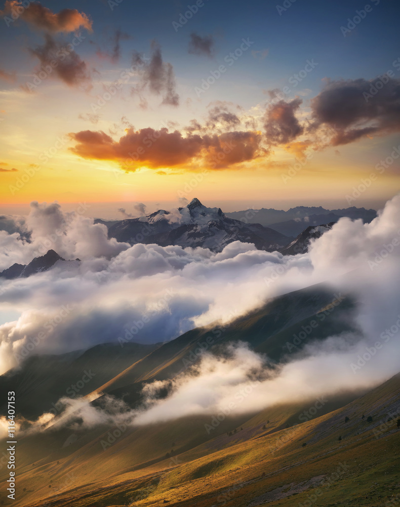 日出时云端的高山山脊。美丽的全景景观