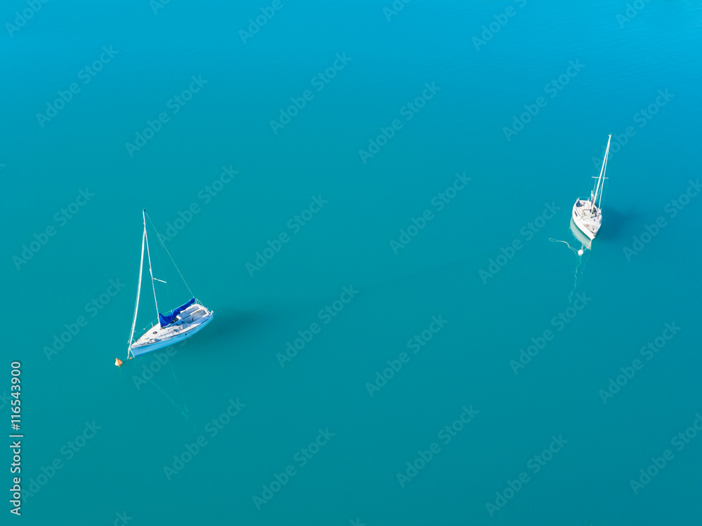 Aerial view of two yachts sailling on azure water