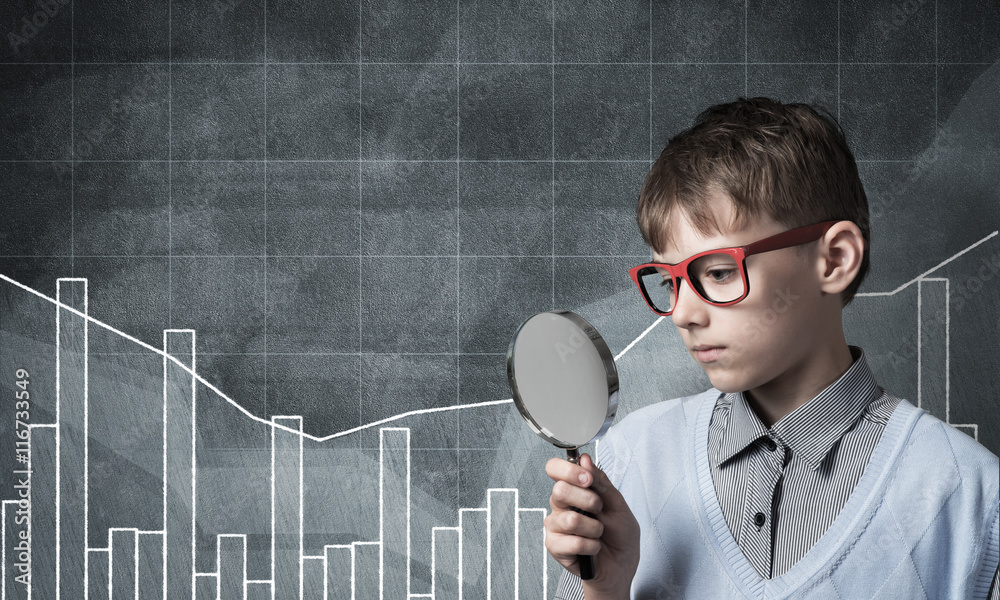 Curious school boy with magnifier