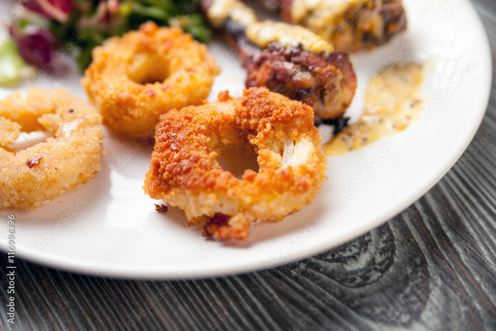 Crunchy fried Onion Rings with salad and roast chicken